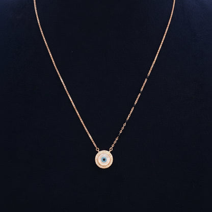 Gold necklace with a blue gemstone pendant on a red fabric background