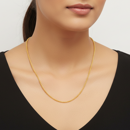 Gold necklace worn by a model on a plain background