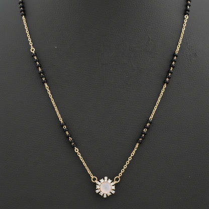 Necklace with black beads and a sunflower pendant on a red fabric background