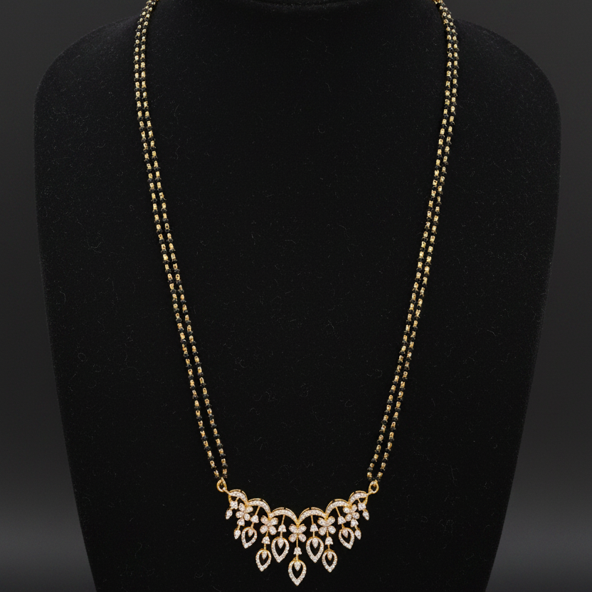 Gold necklace on a mannequin with a red background