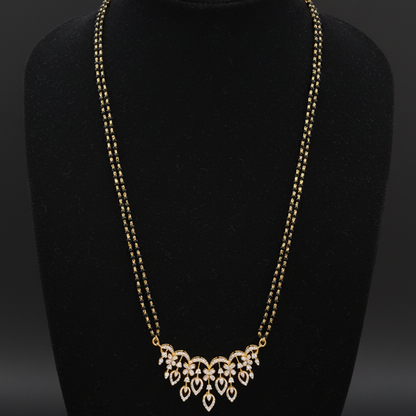 Gold necklace on a mannequin with a red background