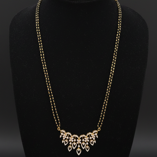 Gold necklace on a mannequin with a red background