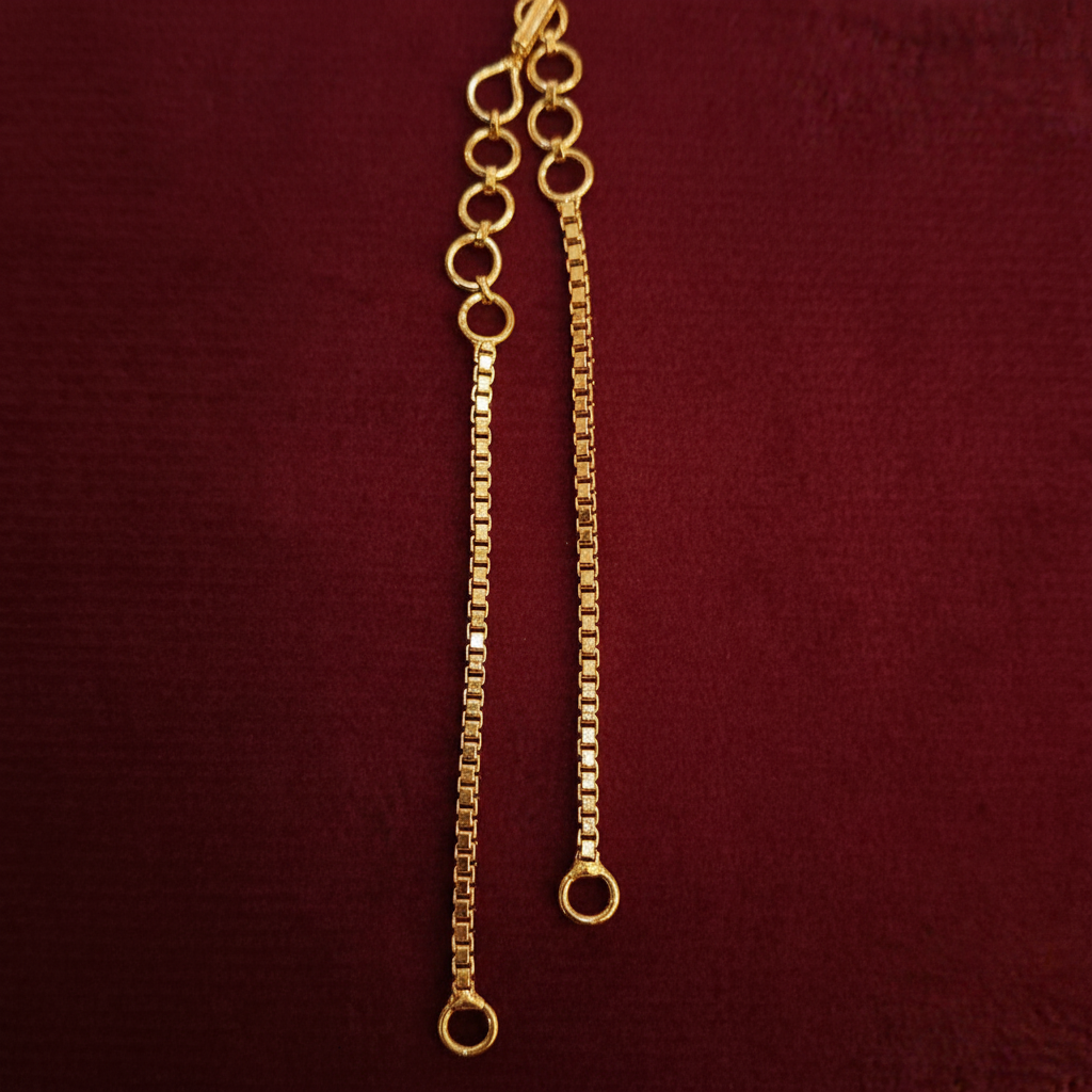 Gold chain on a red fabric background with a visible brand label.