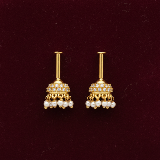 Pair of gold earrings with pearl accents on a maroon background