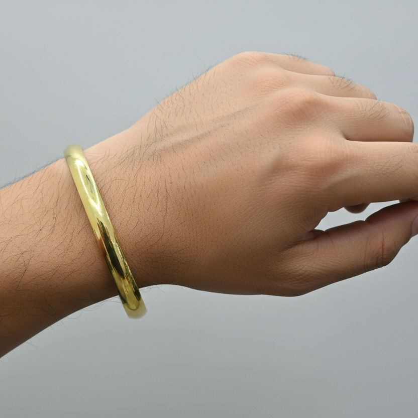 Hand wearing a gold bracelet on a gray background