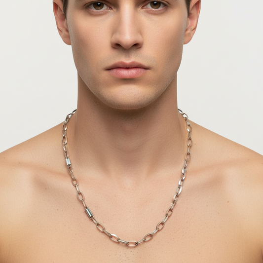 Man wearing a chain necklace against a plain background