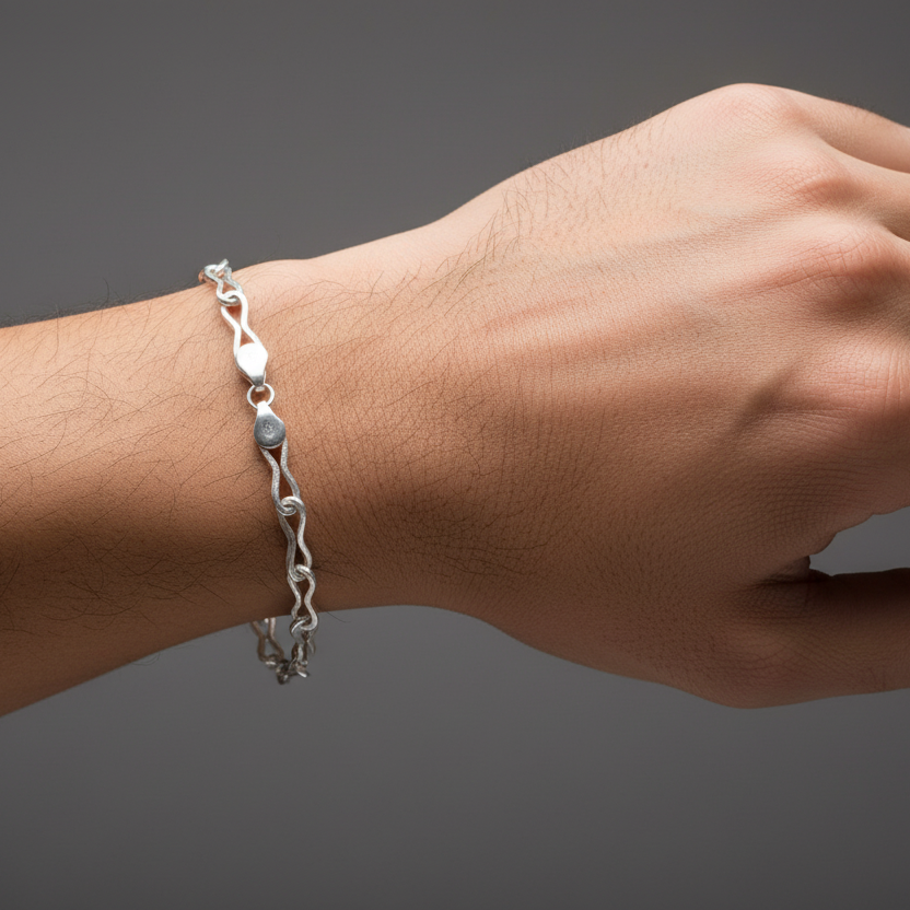 Silver bracelet on a wrist against a dark background