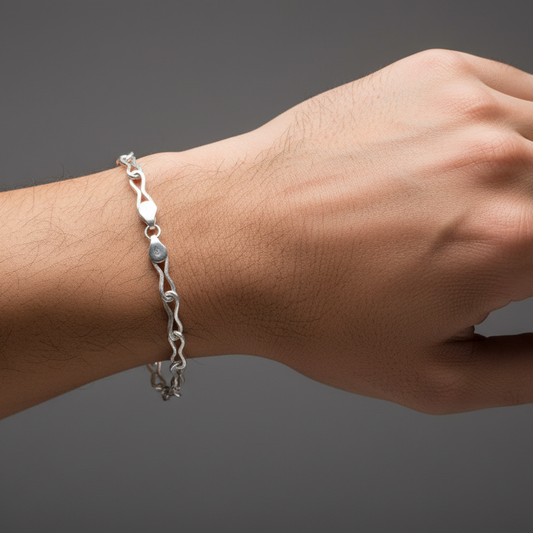 Silver bracelet on a wrist against a dark background