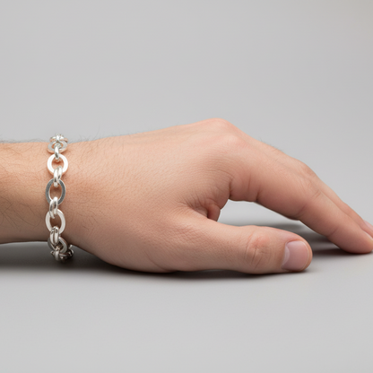 Hand wearing a silver bracelet on a gray background