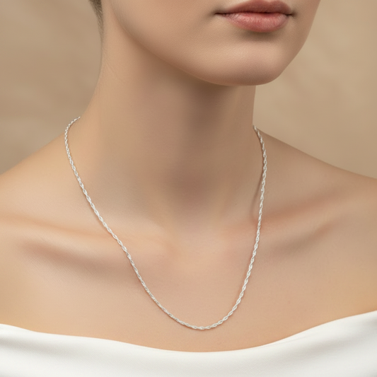 Silver necklace on a model against a beige background